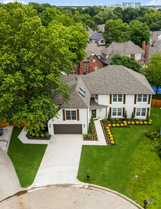 drone shot of front of big suburban home with large driveway
